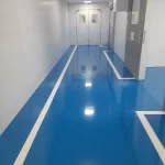 Corredor em epóxi azul com faixas brancas junto à parede