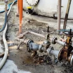 Área industrial com tubulações e piso danificado antes do revestimento