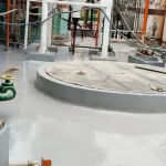 Área industrial com piso em poliuretano cinza e tubulações