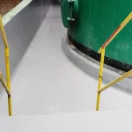 Piso em poliuretano cinza claro com proteção amarela junto a tanque