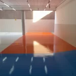 Quadra com piso em resina laranja e borda azul