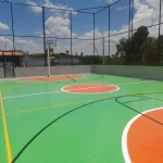 Quadra externa em poliuretano verde e laranja com alambrado