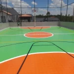 Quadra poliesportiva externa em poliuretano verde e laranja