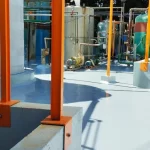 Piso em poliuretano azul claro em área industrial com estrutura laranja