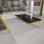 Piso epóxi cinza claro com área preta delimitada por faixa amarela