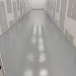 Corredor estreito com piso epóxi cinza brilhante