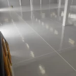 Piso epóxi cinza claro refletindo a luz em sala ampla