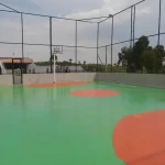 Quadra externa em poliuretano verde e laranja com alambrado