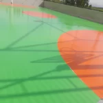 Quadra externa com piso em poliuretano verde e laranja