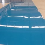 Piso epóxi azul refletindo as luminárias