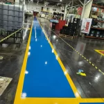 Faixa de circulação em epóxi azul com bordas amarelas em fábrica