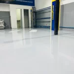 Piso epóxi branco brilhante junto a portas metálicas