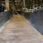 Corredor de fábrica com concreto preparado e lonas de proteção