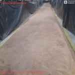Concreto preparado em corredor de fábrica protegido por lonas