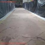 Corredor de fábrica isolado com lonas e concreto preparado para epóxi