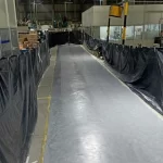 Corredor de fábrica isolado com lonas pretas e piso epóxi cinza recém-aplicado