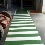 Faixa de pedestres verde e branca em piso epóxi industrial
