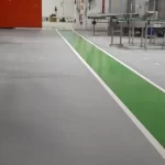 Piso em uretano cinza com faixa de circulação verde