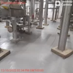 Área industrial com tubulações inox e piso em uretano cinza