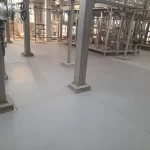 Área industrial com tubulações e piso em uretano cinza