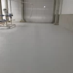 Piso em uretano cinza claro em área industrial com equipamento