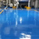 Área industrial com piso em poliuretano azul e faixas amarelas