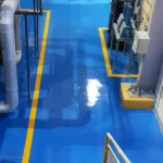 Piso em poliuretano azul com faixas amarelas em área industrial