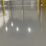 Galpão com piso epóxi cinza claro e estrutura amarela