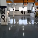 Piso epóxi cinza em oficina com faixas brancas de demarcação