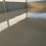 Piso epóxi cinza de alto brilho em galpão vazio