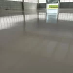 Galpão com piso epóxi cinza refletindo a entrada de luz
