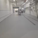 Área de produção com piso em uretano cinza e canaletas