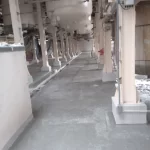 Corredor industrial com pilares e piso em uretano