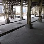 Área industrial com canaletas e piso em preparação