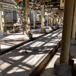 Corredor industrial com pilares e piso em preparação