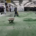 Equipe aplicando uretano verde em piso industrial