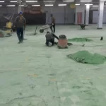 Equipe aplicando uretano verde em galpão