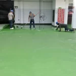 Equipe finalizando piso em uretano verde