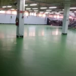 Área industrial com pilares e piso em uretano verde