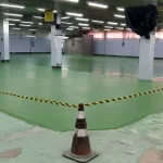 Área isolada com fita de sinalização sobre piso verde desgastado