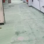 Piso verde antigo desgastado em área industrial