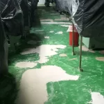 Revestimento antigo verde descascando em área industrial