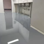 Piso epóxi cinza claro de alto brilho em área técnica