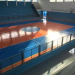 Quadra de ginásio com piso em poliuretano laranja e azul