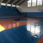 Quadra de ginásio com piso em poliuretano laranja e azul brilhante