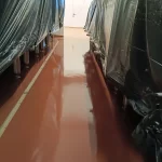 Corredor com piso em poliuretano terracota e lonas de proteção