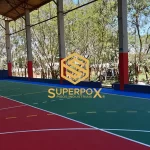 Quadra poliesportiva em pintura acrílica verde e vermelha com logo Superpox