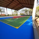 Quadra coberta em pintura acrílica azul com área verde